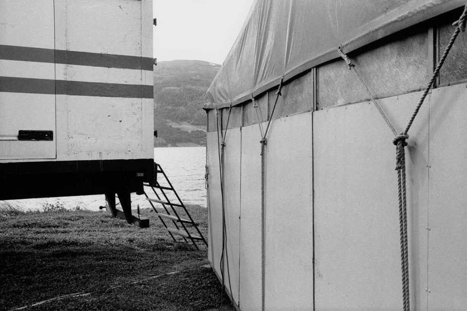 Zwart-wit foto van een tent en een kermiswagen