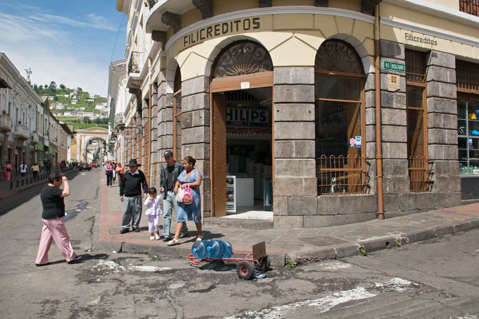 Kleurfoto van een gezelschap komt samen op een straathoek in het historisch centrum van Quito