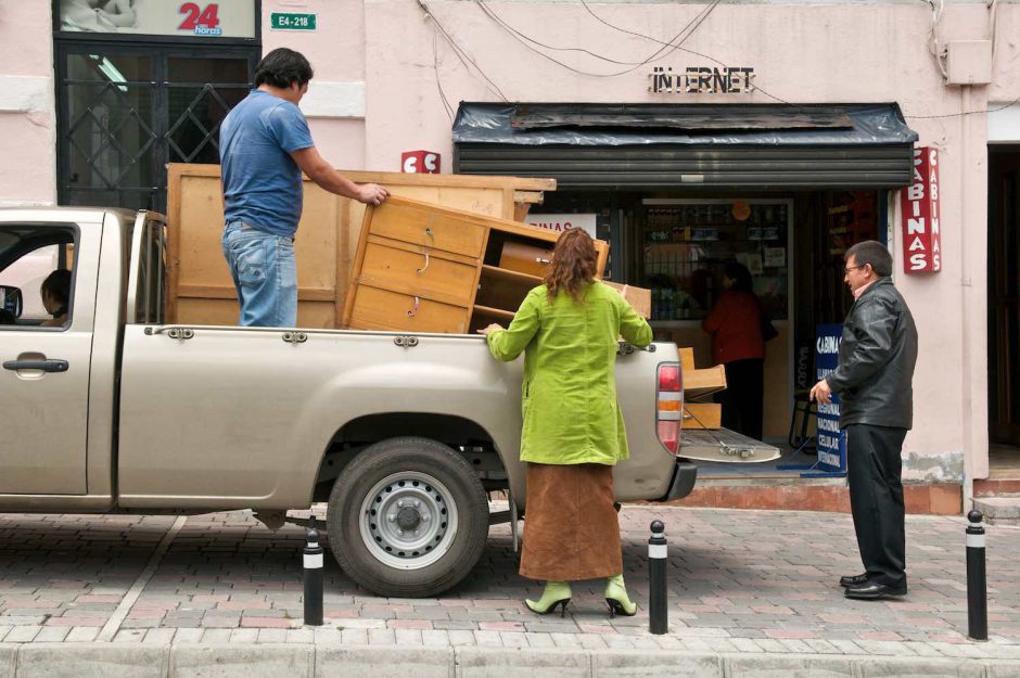 Kleurfoto van mensen die meubilair lossen uit een verhuiswagen