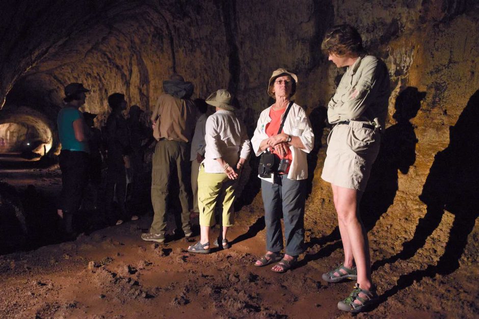 Kleurfoto van een toeristen aan de praat in de lavatunnels van Isla Isabela