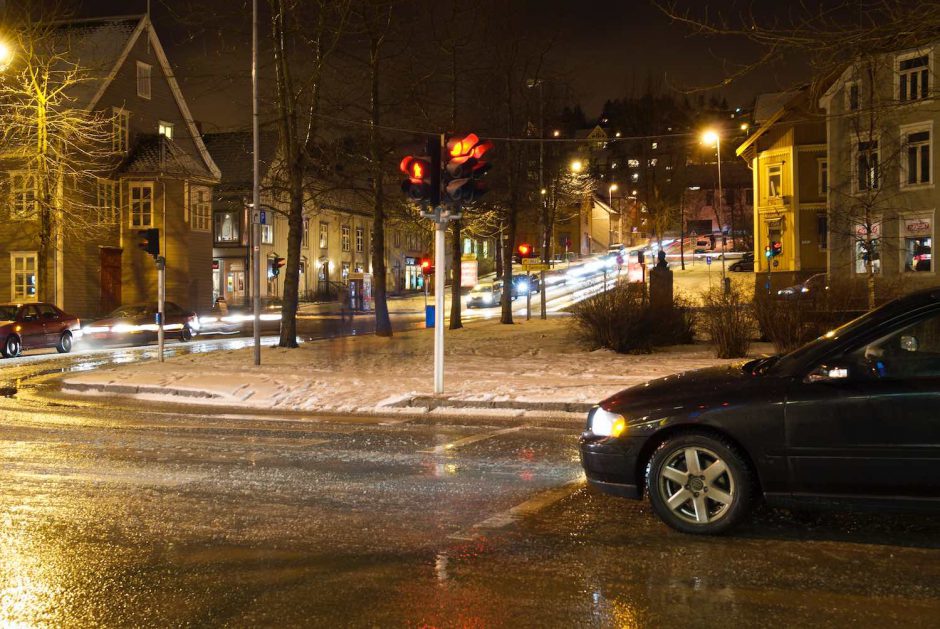 Kleurfoto van een stilstaande auto aan verkeerslichten in Tromsø