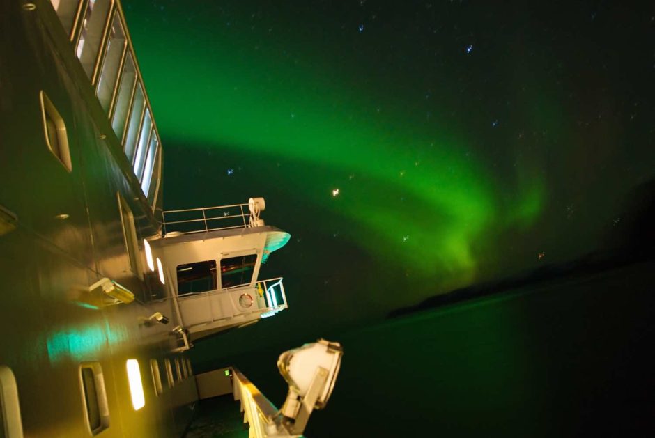 Kleurfoto van de aurora borealis vanop het dek van de Polarlys