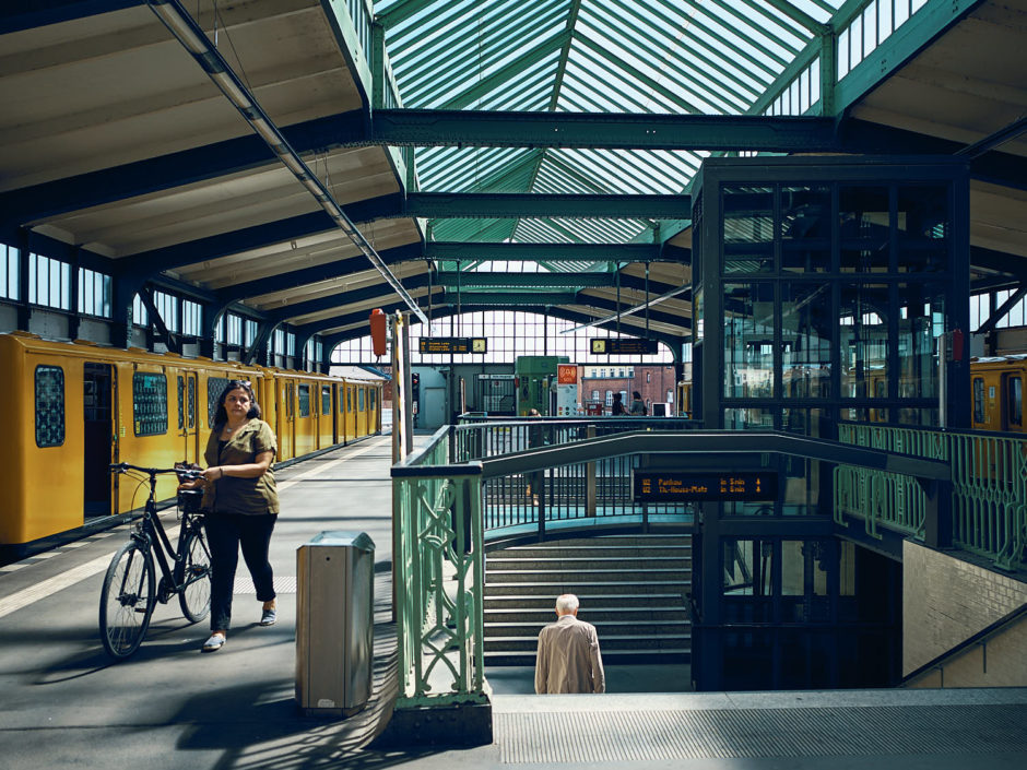 Kleurenfoto van een dame met fiets in een treinstation