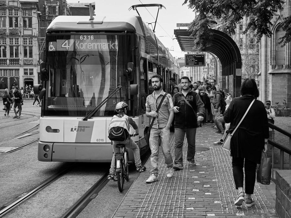 Zwart-wit foto van jonge mannen aan tram 4 in de Cataloniëstraat in Gent