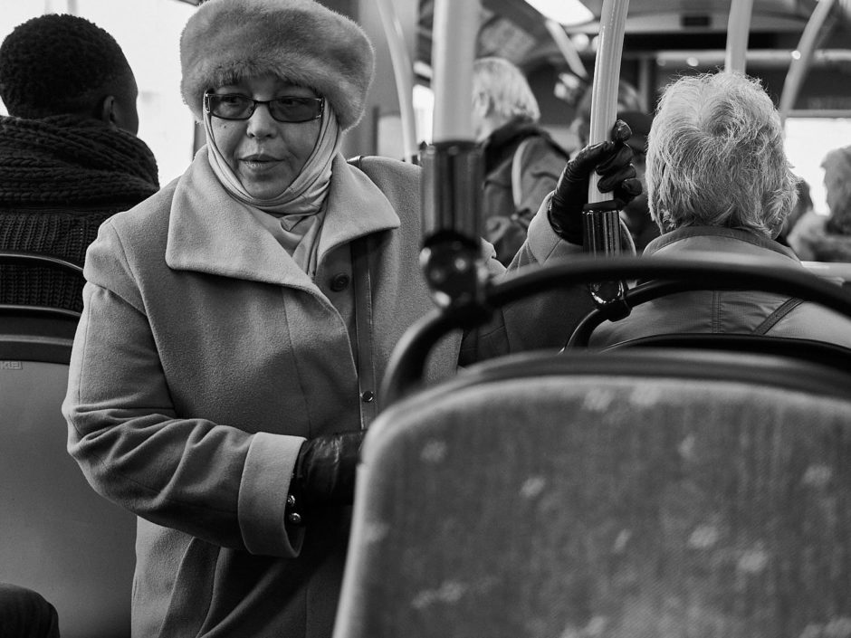 Zwart-wit foto van een oudere dame op bus 3 in Gent