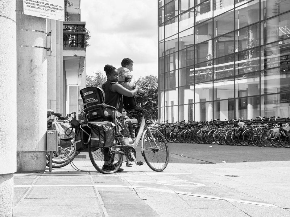 Zwart-wit foto van een jonge moeder met kinderen en fiets