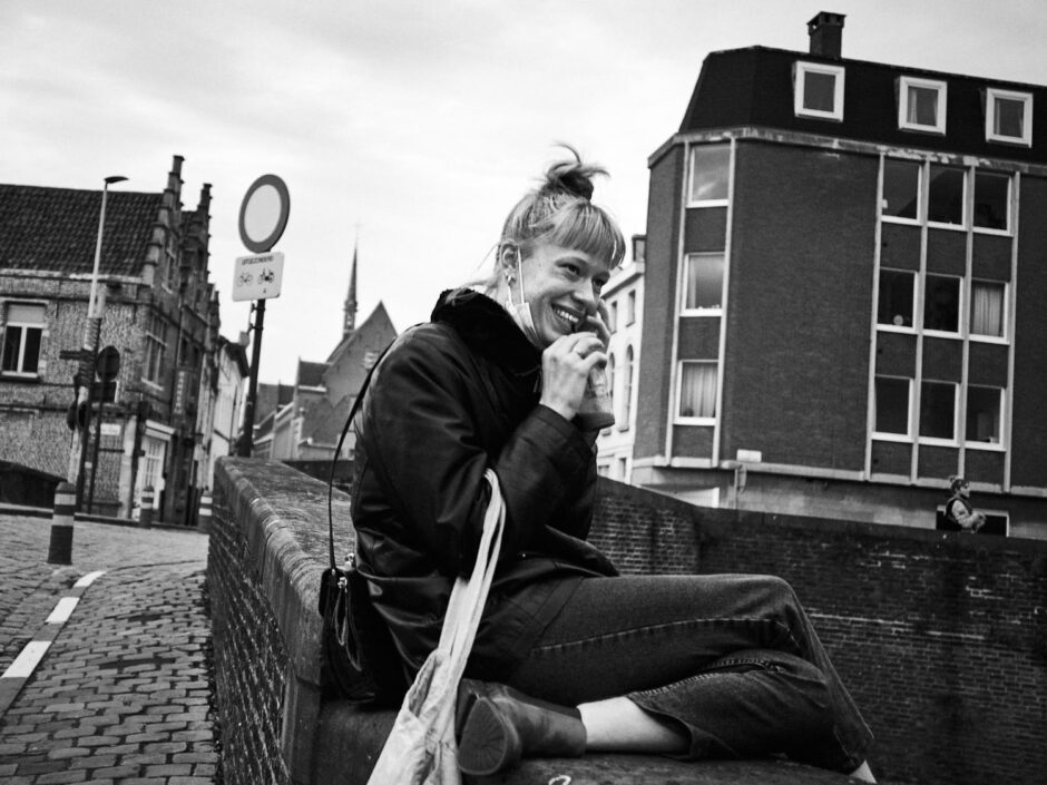 Black & white street photography of homo urbanus, more precisely of a young woman having a exhilarate telephone conversation