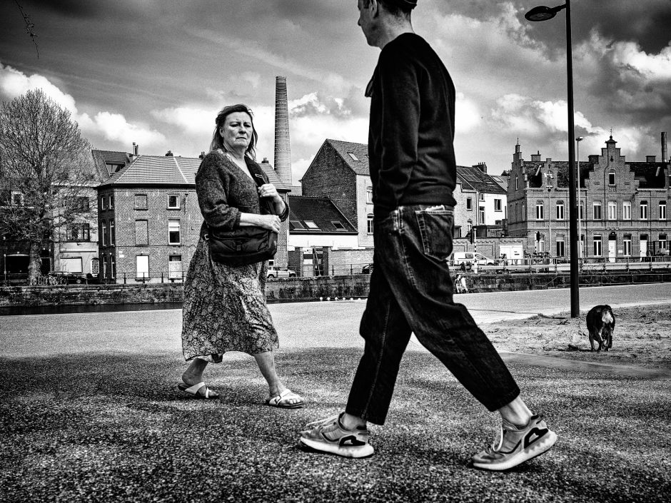 Black & white photograph of two strangers passing by